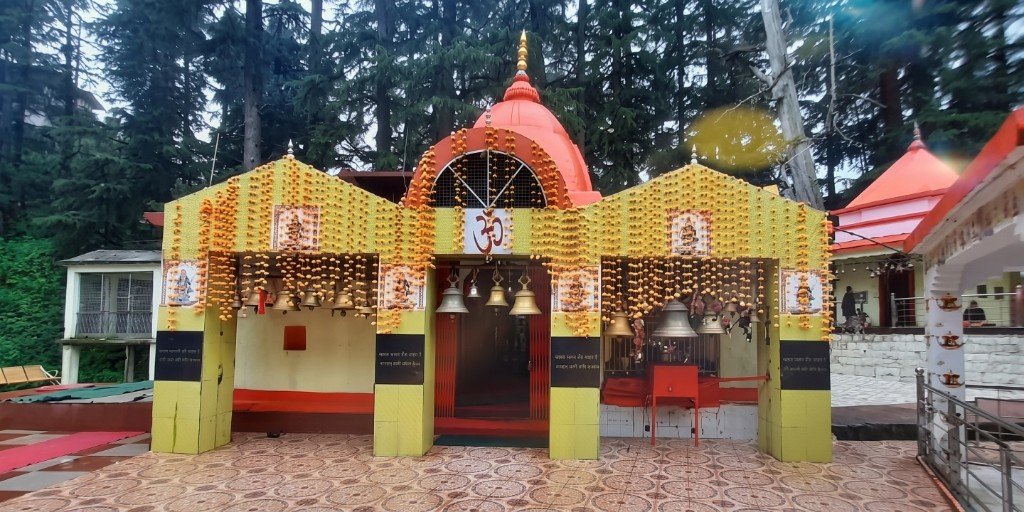 Maa Haat Kalika Temple Gangolihat — main sanctum entrance adorned with brass bells and victory offerings from Kumaon Regiment soldiers